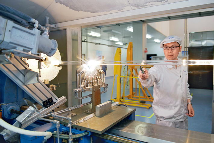 A worker of Fasten Group makes optical fiber perform with Modified Chemical Vapor Deposition facilities.  by Chen Ye