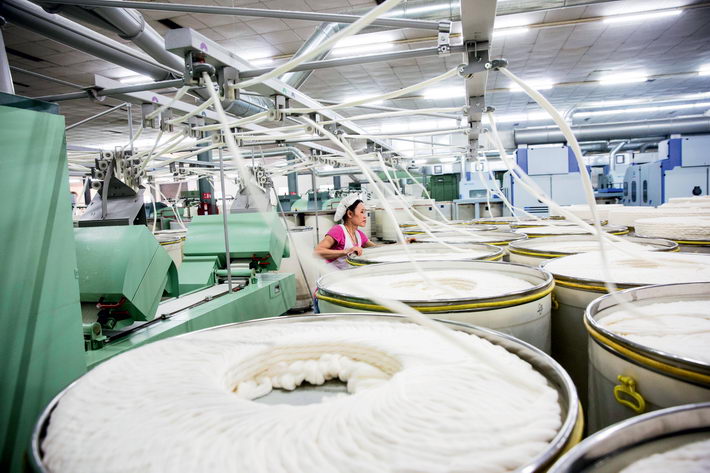 A spinning workshop at the textile factory of Huaxi Village in Jiangyin.  by Qin Bin