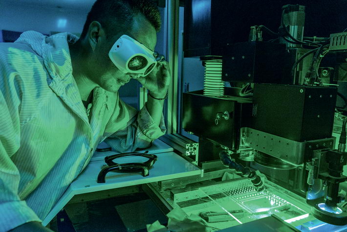 At the research workshop of Deli Laser Solutions in Jiangyin, a worker performs a glass drilling experiment.  by Pang Zhijian