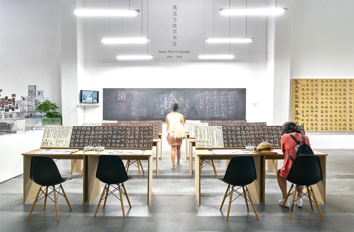 Square Word Calligraphy Classroom by Xu Bing, mixed media installation, dimensions variable, 1997. As visitors enter the “calligraphy classroom,” writing and watching videos create a more immersive experience.